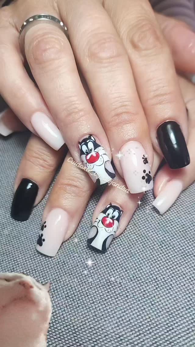 Uñas nude y negras con diseño de gato Silvestre